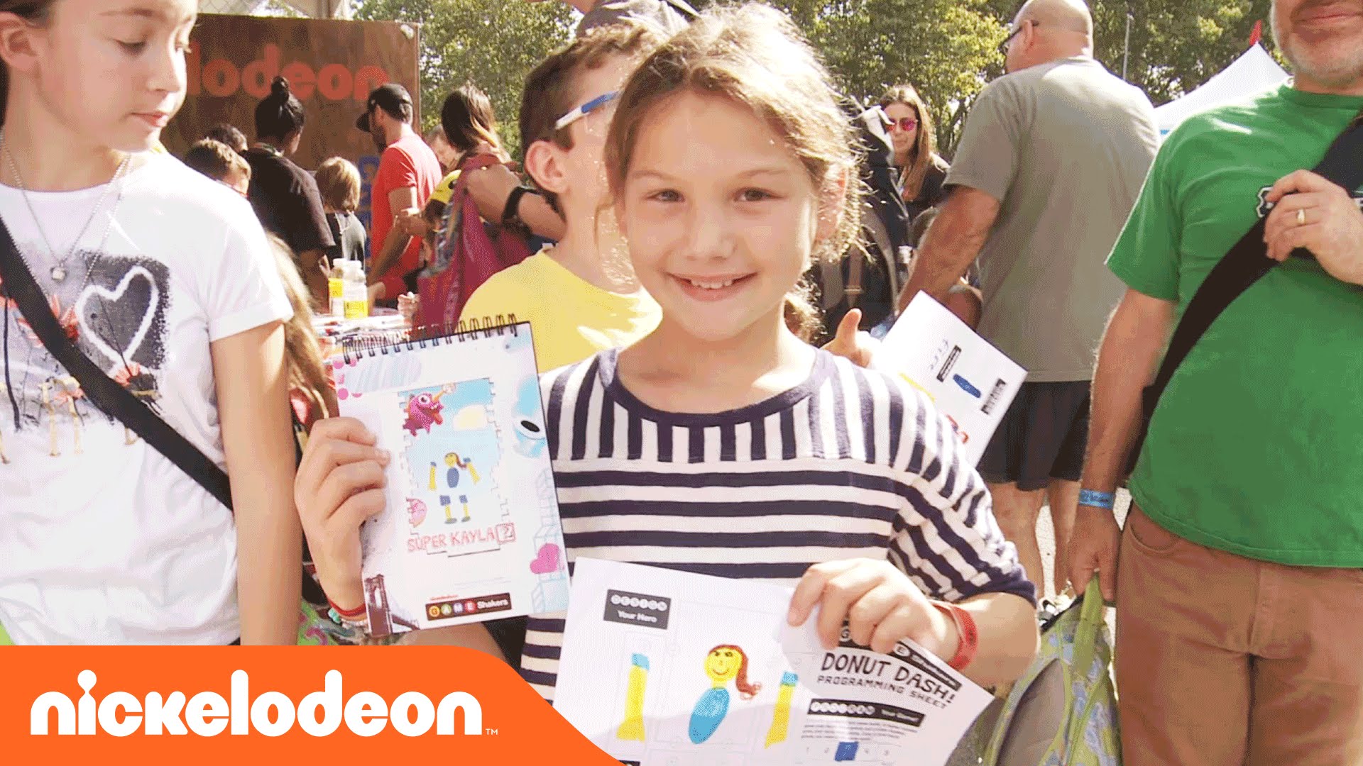 a girl holding up a custom notebook with Nickelodeon branding